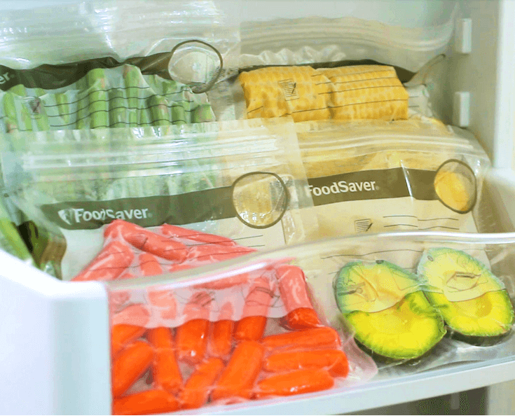 Poukładane w lodówce woreczki z żywnością zapakowaną prózniowo
